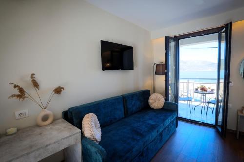 萨米SAMI BAYVIEW的一间带蓝色沙发的客厅和一个阳台
