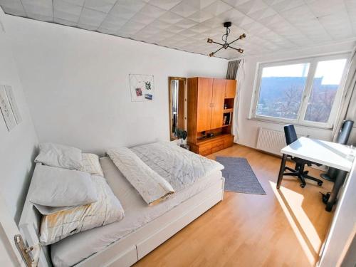 维也纳Best Rated Central Apartment Vienna - AC, WiFi, 24-7 Self Check-In, Board games, Netflix, Prime的一间卧室配有一张床、一张书桌和一个窗户。