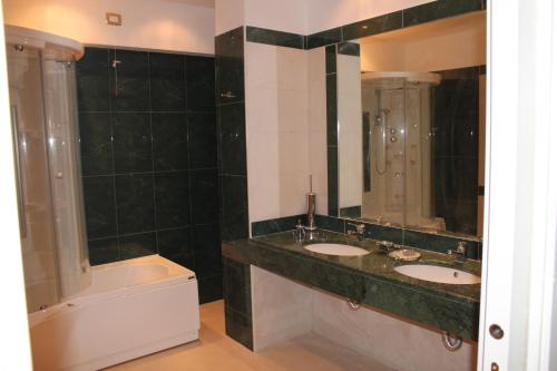 锡拉库扎Aretusa Palace Hotel的浴室配有两个盥洗盆和浴缸。