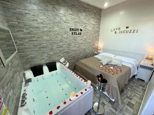 斯卡法蒂Il FAUNO - Suite & SPA的卧室配有床和浴缸