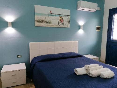 奇尼斯B&B Santorini的蓝色卧室,配有带毛巾的床