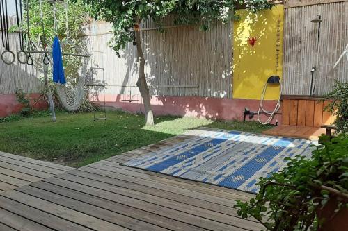 埃拉特Cosy Family Home & Garden in Eilat的庭院,地面上设有木甲板和垫子