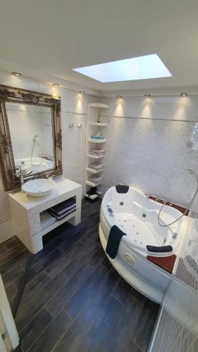 WarmondLake House 74, luxury accommodation ir Sauna的带浴缸、水槽和镜子的浴室