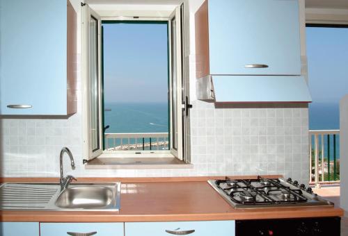 佩斯基奇Pensione La Torretta的厨房配有水槽、炉灶和窗户。