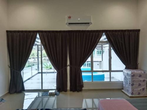 居銮D'Corner Homestay Kluang Perdana的客房内的大窗户和窗帘