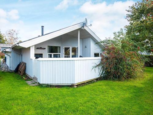 森讷比8 person holiday home in Juelsminde的院子中带围栏的白色房子