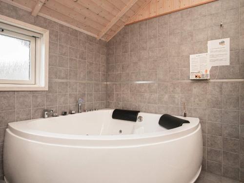 温讷鲁普6 person holiday home in Vinderup的带窗户的浴室内的白色浴缸