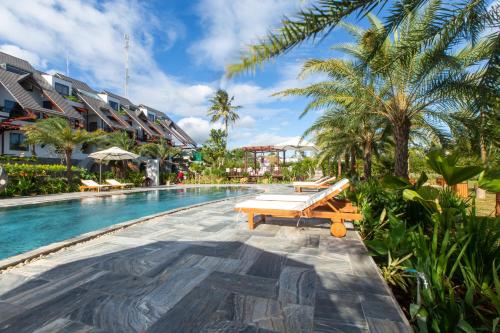 Buôn JuHami Garden - Authentic & Natural Resort的棕榈树和长凳的度假村的游泳池