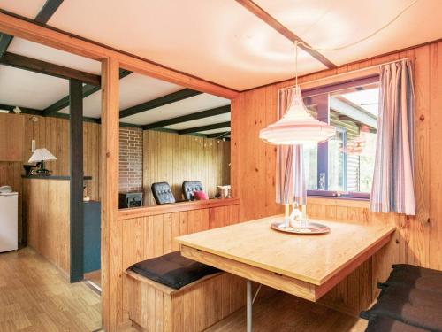 Bøstrup5 person holiday home in H jslev的一间带木桌和窗户的用餐室