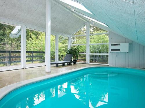 Øksenmølle6 person holiday home in Ebeltoft的一座有窗户的房子里的一个空游泳池