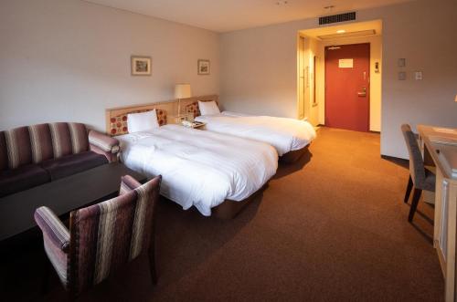 落合中津川温泉　ホテル花更紗的酒店客房,设有两张床和一张沙发