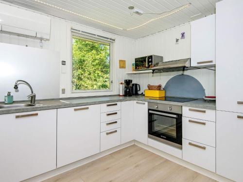 Nørby6 person holiday home in Ringk bing的白色的厨房配有白色橱柜和窗户