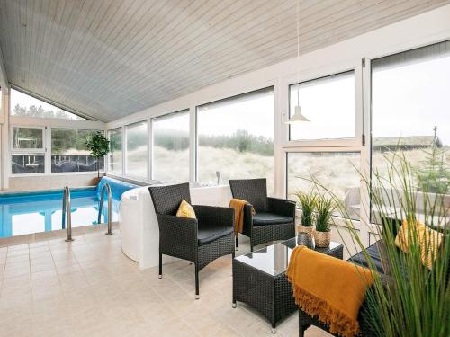 格隆霍12 person holiday home in L kken的庭院设有游泳池、椅子和桌子。