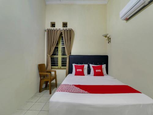 CimahiOYO 90892 My Guest House Syariah的一间卧室配有一张带红色枕头的大床