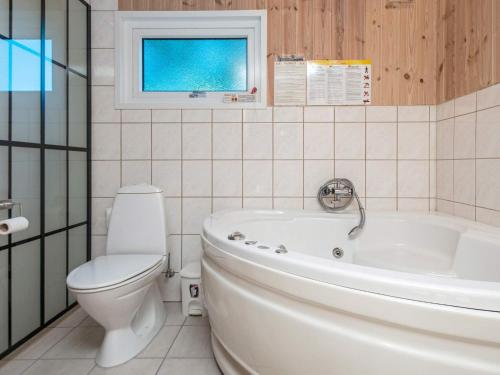格莱斯堡8 person holiday home in Glesborg的带浴缸、卫生间和盥洗盆的浴室