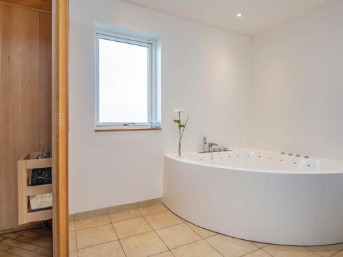 哈泽斯莱乌10 person holiday home in Haderslev的带窗户的浴室内的白色大浴缸