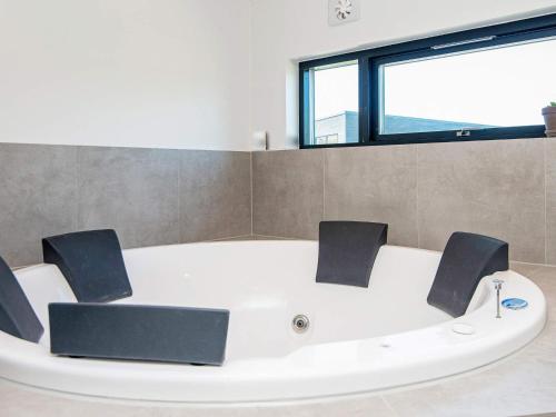格莱斯堡16 person holiday home in Glesborg的窗户客房内的白色浴缸