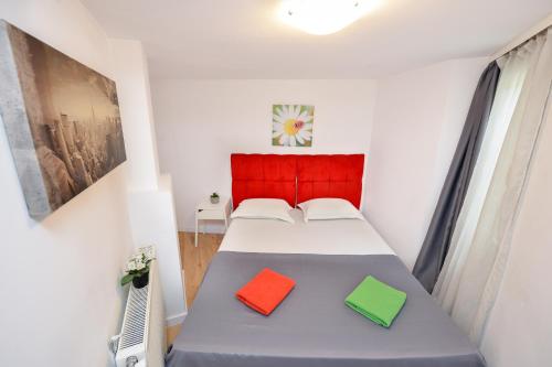 布加勒斯特Harmony Residence的一间卧室配有一张带两个色彩缤纷的枕头的床。