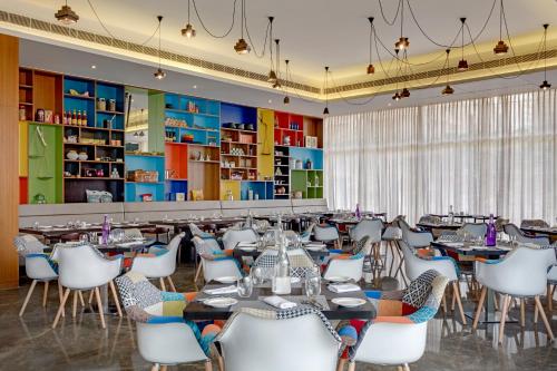 赖布尔Triton By Shyama Hotels & Resorts的用餐室配有桌子和白色椅子