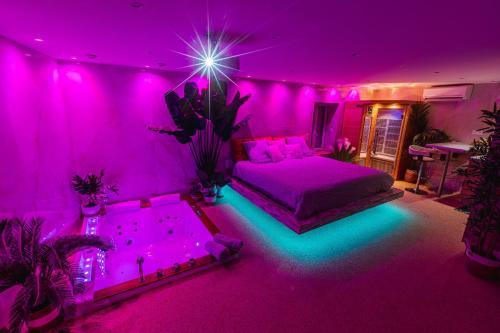 奥比埃La Suite d'Aubière的紫色的客房设有一张床和一个浴缸。