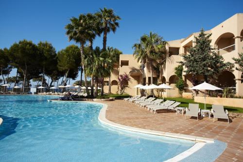 圣埃乌拉利亚格鲁桑塔艾拉Spa酒店（仅限成人入住）的度假村的游泳池,配有椅子和遮阳伞