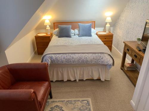 艾尔斯伯里83的一间卧室配有一张带蓝色枕头的床和一把椅子
