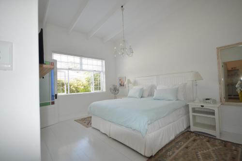 开普敦Willow Cottage的白色的卧室配有白色的床和镜子