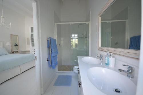 开普敦Willow Cottage的白色的浴室设有2个盥洗盆和淋浴。