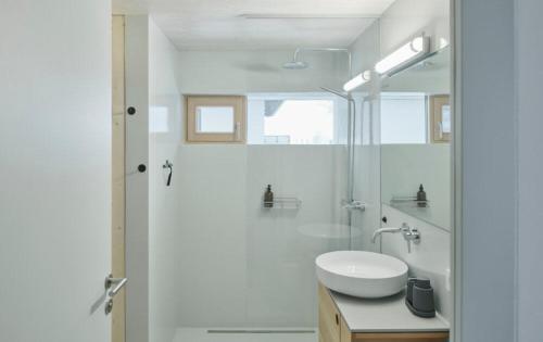 毛拉赫Urban Alpine Penthouse with Lake View的白色的浴室设有水槽和淋浴。