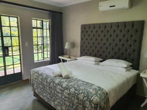 路易特里哈特Avoca Vale Country Hotel的一间卧室配有一张大床和大床头板