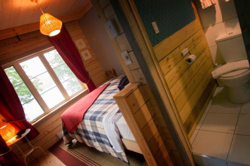 Saint-Raymond七岛港拉克庄园宾馆的一间小卧室,配有一张床和一个卫生间