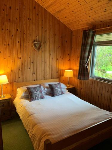 MorenishMilton Bay Luxury lodge wrapped in exceptional scenery的一间卧室配有一张带两盏灯的床和一扇窗户。