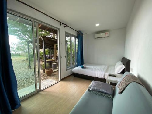 马六甲乐图度假屋的一间卧室设有一张床和一个滑动玻璃门