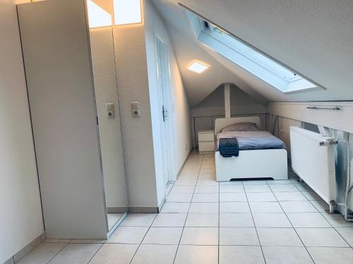威斯巴登3 Room Apartment in Wiesbaden的一间小卧室,配有一张床,铺有瓷砖地板