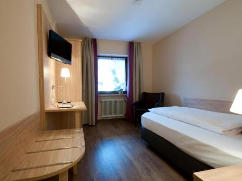 格拉绍Hotel-Gasthof Sperrer的酒店客房,配有床和电视