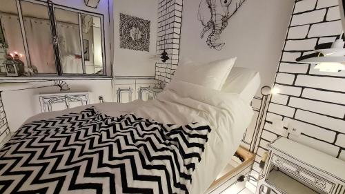 萨尔特河畔萨布雷Studio illustré Insolite的白色卧室配有黑白色的床