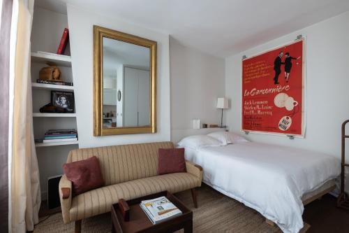 巴黎Luxe Atelier bail mobilité Saint germain des Près的一间卧室配有一张床、一张沙发和一面镜子