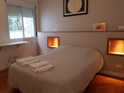 圣保罗Casa Saint Hilaire的一间卧室配有一张床,上面有两条毛巾