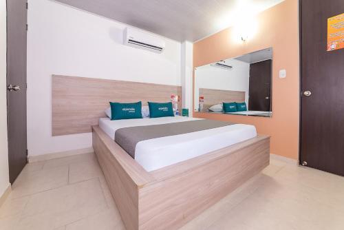 库库塔Ayenda Hospedaje WIV的一间卧室配有一张大床和镜子