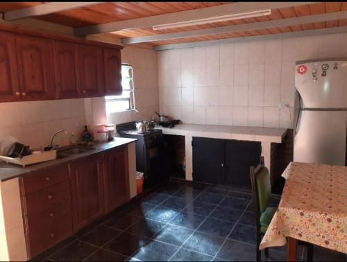特尔马斯德里奥翁多Habitaciones Daniel的厨房配有木制橱柜和白色冰箱。