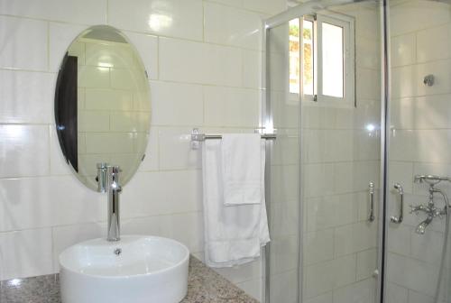 海地角Vue Apartment Hotel的浴室配有盥洗盆和带镜子的淋浴