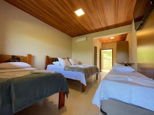 伊帕廷加Tijota Hotel Fazenda的一间房间,有三张床