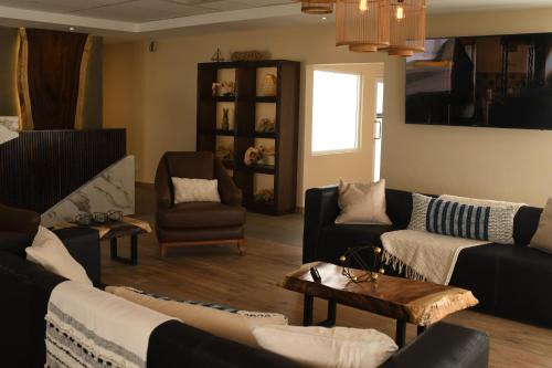 华雷斯城Hotel Dunas Near Consulate的带沙发、椅子和桌子的客厅