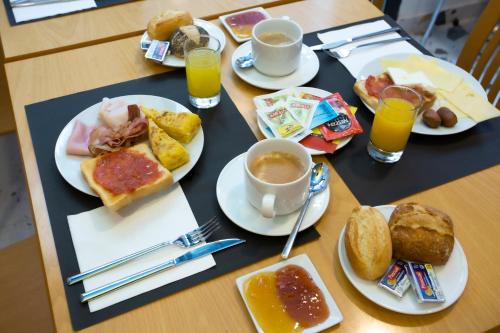 巴塞罗那Casual Colours Barcelona的餐桌上摆放着早餐食品和饮料