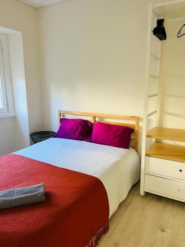 里斯本Lovely Apartment to feel Lisbon的一间卧室配有一张带红色枕头和架子的床