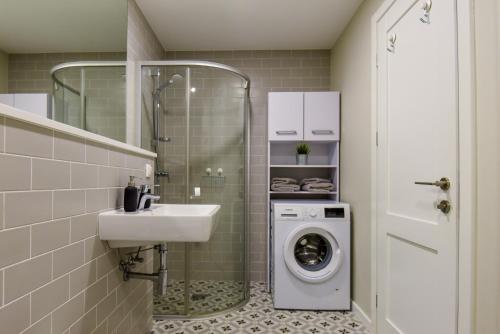 斯文托伊Apartamentai Elija su vaizdu į jūrą的一间带洗衣机和水槽的浴室