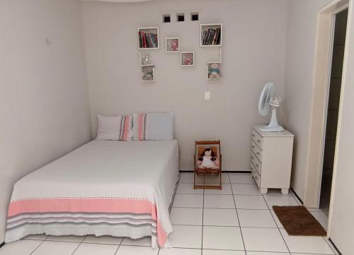 福塔莱萨Sua casa fora de casa的一间白色卧室,配有一张床和一个小橱柜