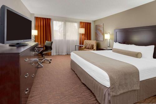 迈阿密Sonesta Miami Airport的配有一张床和一台平面电视的酒店客房