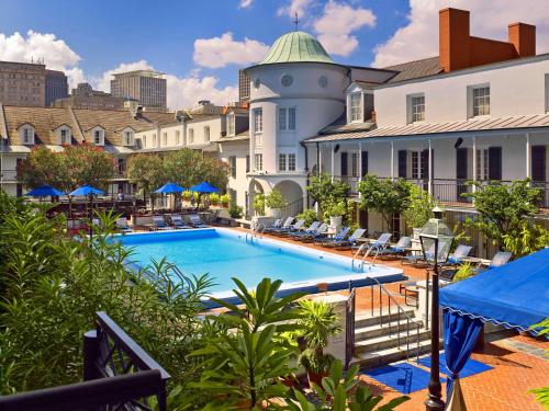 新奥尔良The Royal Sonesta New Orleans的享有酒店游泳池的景色,设有椅子和大楼