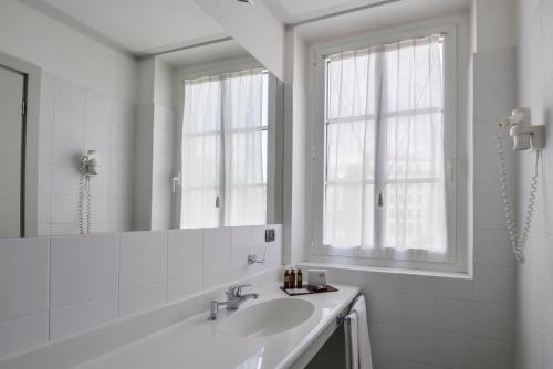 的里雅斯特阿尔伯格亚拉珀斯塔酒店的白色的浴室设有水槽和镜子